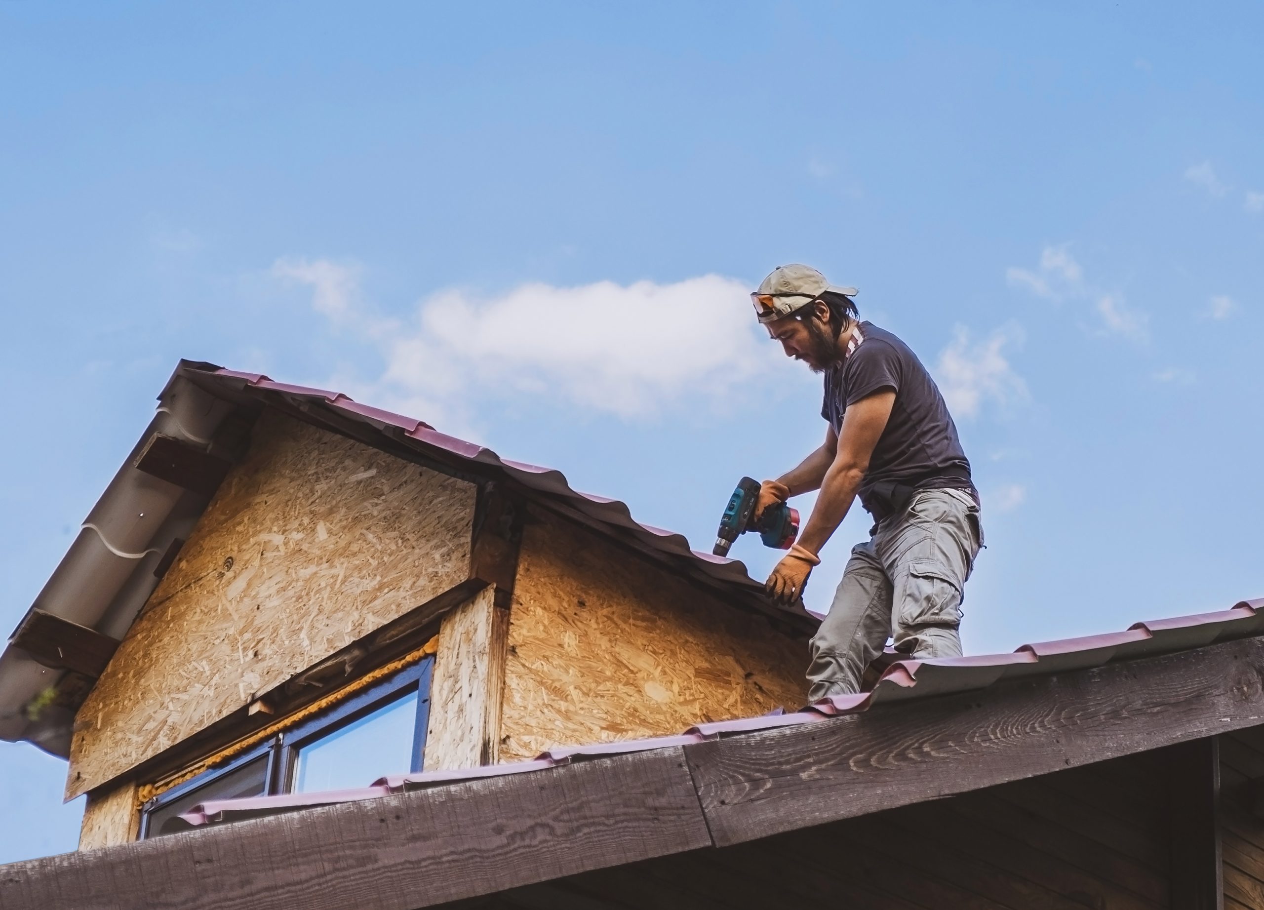 man-working-roof-with-drill in city